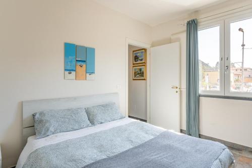a white bedroom with a bed and a window at Casa Moki in Uliveto Terme