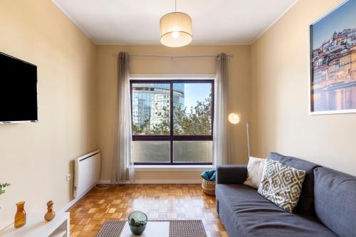 a living room with a couch and a large window at Destiny Oporto in Maia