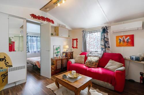 a living room with a red couch and a table at Mobilehome 5 personnes in Les Mathes