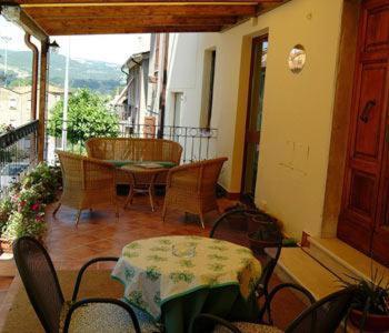 a room with a table and chairs on a balcony at Hotel Picchio in Orvieto