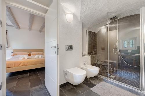 a bathroom with a toilet and a shower and a bed at La Guardiola I By Immobilux in Riva del Garda
