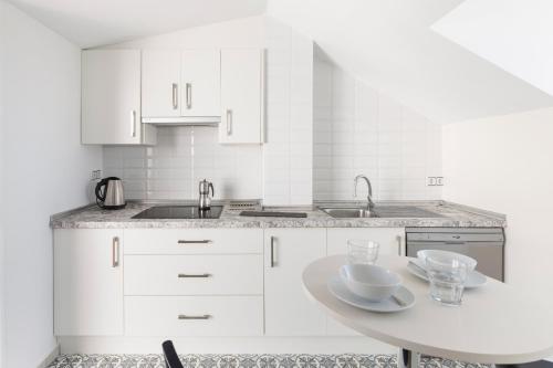 a kitchen with white cabinets and a table with bowls on it at Primera Planta in Cartagena