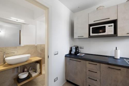 a bathroom with a sink and a microwave at Lo Sarvanot in Bernezzo
