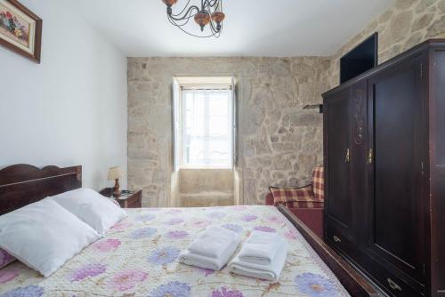 a bedroom with a bed with two towels on it at Casa De Marica in A Estrada