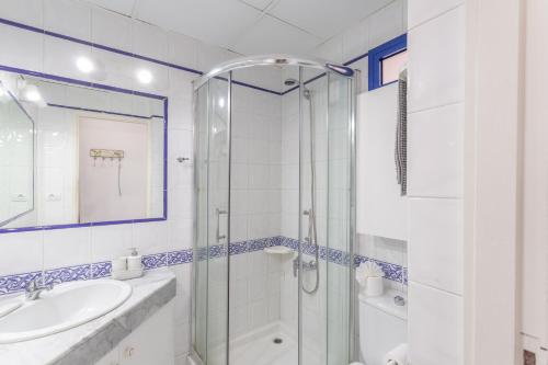 a white bathroom with a shower and a sink at Brisas Canarias in Puerto Rico de Gran Canaria
