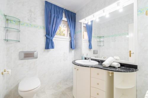a white bathroom with a toilet and a sink at Villa Epi in Cala Ratjada
