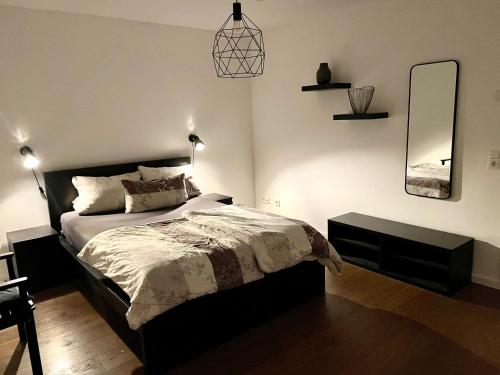 a bedroom with a bed and a mirror on the wall at Gemütliche Ferienwohnung in Drolshagen