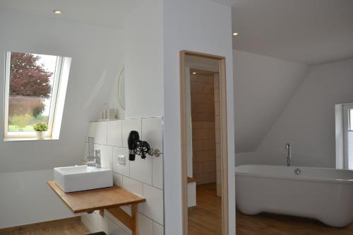a bathroom with a tub and a sink and a bath tub at Gut Bennewohld in Heide