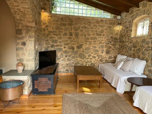 a living room with a couch and a fireplace at Traditional Stone House in Lazaráta