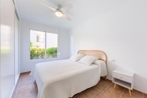 a white bedroom with a bed and a window at Apartamento Luz De Baria in Vera
