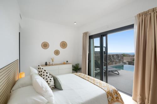 a bedroom with a bed and a balcony with a pool at Yucas Villa 13 in San Bartolomé