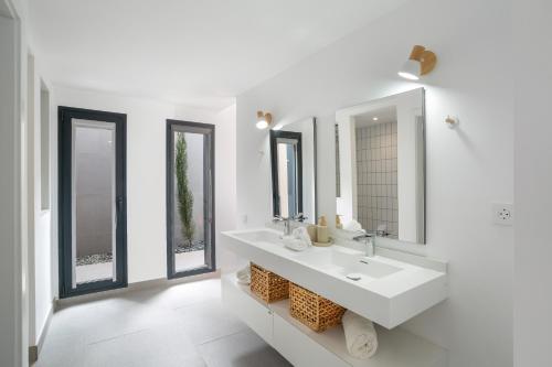 a white bathroom with a sink and two mirrors at Yucas Villa 13 in San Bartolomé