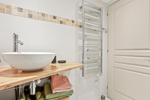 a bathroom with a bowl sink on a wooden shelf at Charmant appartement avec terrasse in Brignoles