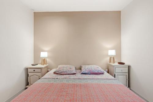 a bedroom with a bed with two pillows on it at Charmant appartement avec terrasse in Brignoles