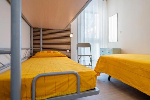 a bedroom with two beds and a chair in it at beach and pool in Cambrils