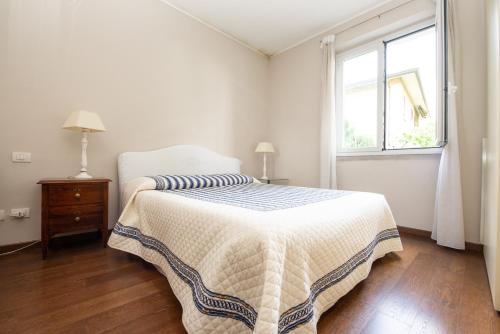 a white bedroom with a bed and a window at Stanza in Villa Magica in Credaro