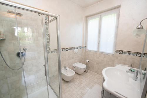 a bathroom with a shower and a toilet and a sink at Stanza in Villa Magica in Credaro
