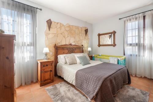 a bedroom with a bed and a stone wall at Villa María in Taco