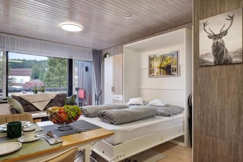 a bedroom with a bed and a table in a room at Quality Time auf 1000 Meter in Schönwald