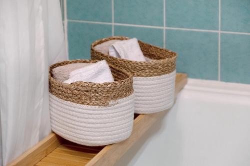 two baskets sitting on a shelf next to a bath tub at Quality Time auf 1000 Meter in Schönwald