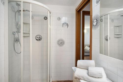 a white bathroom with a shower and a sink at Il Giardino del Sole, Chalet Salvia in Garlenda