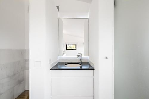 a white bathroom with a sink and a mirror at Dalt Son Morro in Santa Margalida