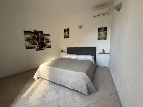 a bedroom with a bed in a white room at Essenedda Holiday Home in Orosei