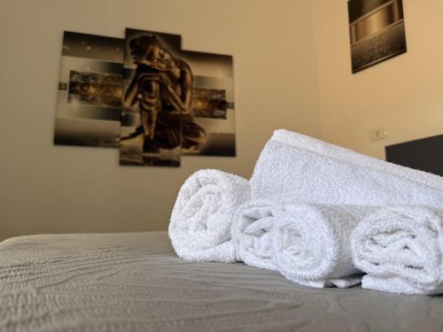 a pile of towels sitting on top of a bed at Essenedda Holiday Home in Orosei