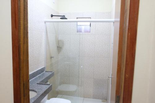 a bathroom with a shower with a toilet and a sink at Refúgio Paraíso in Santo Amaro