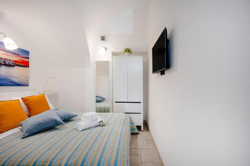 a bedroom with a bed and a flat screen tv at Tritone 30 in Polignano a Mare