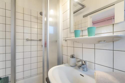 a white bathroom with a sink and a shower at Ferienwohnung Wencke in Büsum