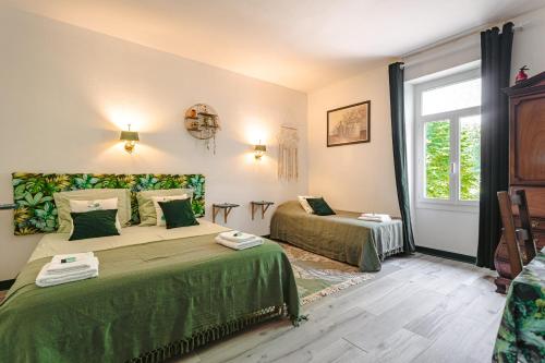 a bedroom with two beds and a window at Chambre d'hote Emeraude in Genouillé