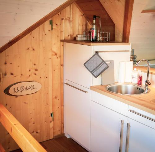 a kitchen in a log cabin with a sink at Villa Wolfsgrund und Apt Wolfshöhle in Schluchsee