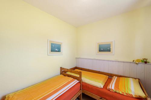 two wooden beds in a room with two pictures on the wall at Möve Aba Appartment 11 in Rerik