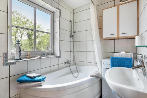 a bathroom with a tub and a sink and a toilet at De Lüüte Kaat in Offenbüttel
