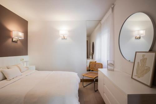 a bedroom with a large white bed and a mirror at Santa Teresuca en Santander in Santander