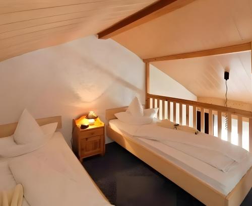a room with two beds and a table with a lamp at Hotel Schachten in Lindberg