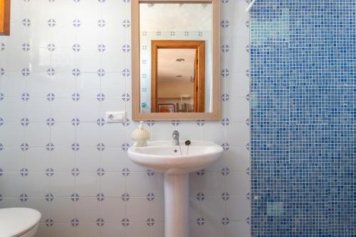 a bathroom with a sink and a mirror and a shower at Fuente luz cottage in Frigiliana
