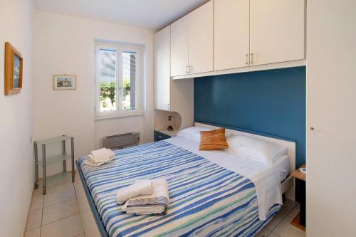 a bedroom with a blue and white bed with towels on it at Casa vacanze al Boschetto in Masina