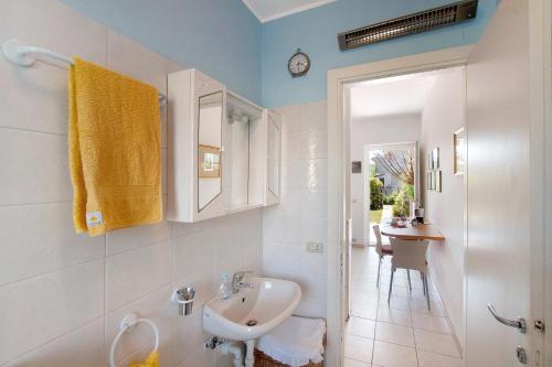 a white bathroom with a sink and a mirror at Casa vacanze al Boschetto in Masina