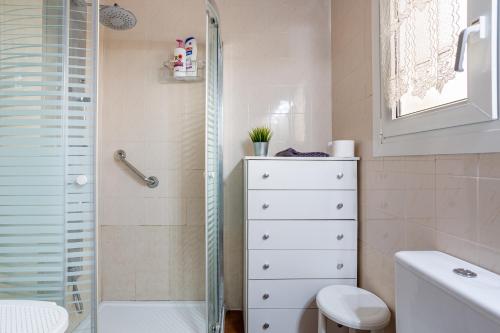 a bathroom with a shower and a white dresser at Maison La Coquette L' Escala in L'Escala