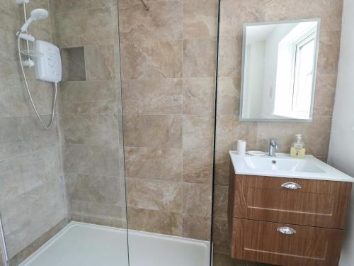 a bathroom with a shower and a sink at Craig Mawr in Benllech