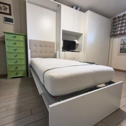 a bedroom with a bed and a green dresser at Modern Practical Studio In Sauze in Sauze d'Oulx