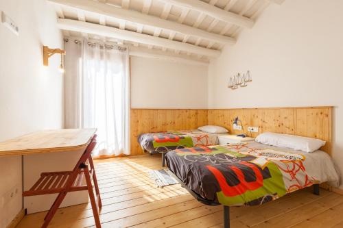 a bedroom with two beds and a desk in it at Sant Rafel House in Arenys de Mar