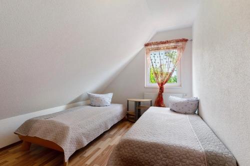 two beds in a room with a window at Ferienhaus Waldfee in Reutin