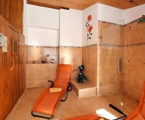 a bathroom with orange chairs and a shower at Hotel Schachten in Lindberg