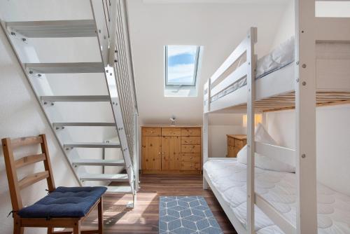 a room with two bunk beds and a chair at Abendsonne in Koserow