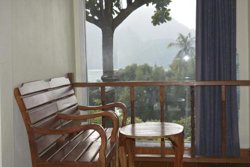 a chair and a table on a balcony with a tree at Phi Phi View Point Resort in Phi Phi Don