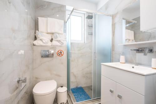 a bathroom with a shower and a toilet and a sink at Velvet Apartments in Rhodes Town