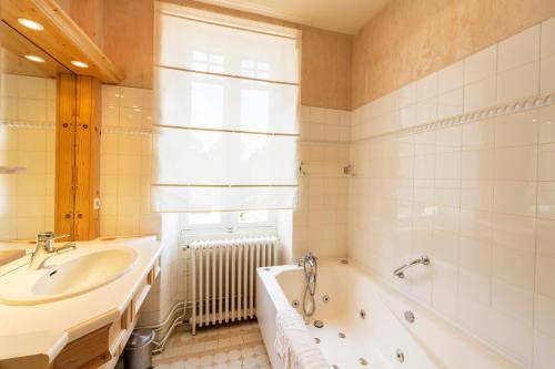 a bathroom with a tub and a sink and a bath tub at Villa d’Exception, Piscine, Parc in Soustons